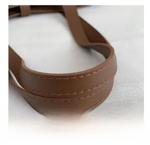 Close-up of brown litchi pattern leather shoulder strap with detailed stitching