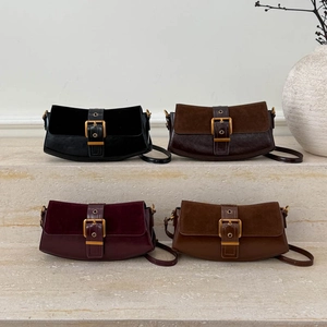 Retro suede hobo bag with gold buckle in four colors displayed on stone steps
