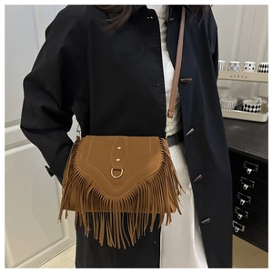 Nahaufnahme der braunen Wildledertasche mit langen Fransen und Goldapplikationen