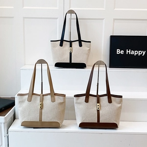Three minimalist canvas tote bags in black, khaki, and brown with gold metal buckle accents