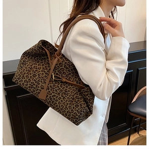 Chic leopard print tote bag with brown leather straps worn with a white blazer