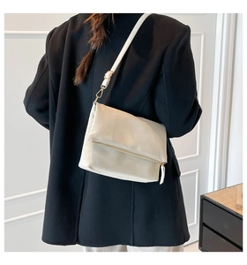 Beige rectangular envelope shoulder bag with gold metal buckles shown on model