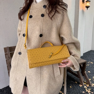 Chic yellow ostrich-embossed baguette bag with a golden twist lock and long shoulder strap