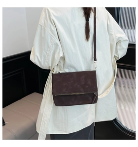 Coffee brown suede envelope crossbody bag shown from behind on a model shoulder