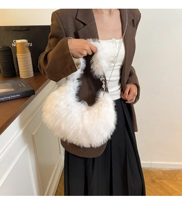 Detailed view of white faux fur shoulder bag with silver chain and heart charm detail