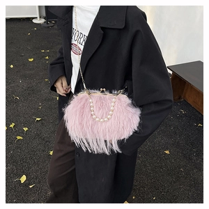Dettaglio borsa di peluche rosa con manico di perle e chiusura a scatto dorata