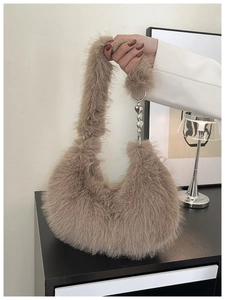 Detail of brown faux fur hobo bag with silver heart chain and soft plush texture
