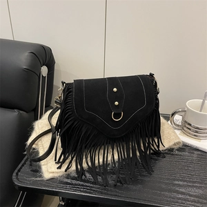 Black matte suede crossbody bag featuring long fringe tassels and gold D-ring hardware