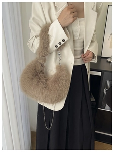 Close-up of fluffy brown faux fur bag with silver chain and heart-shaped metal pendant