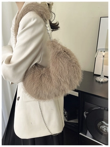 Furry crescent bag with pearl chain detail shown on model in a modern office setting