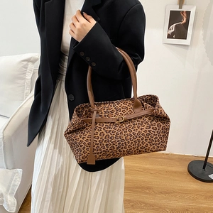 Fashionable leopard print tote bag with leather handles and decorative buckle detail
