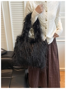 Detail of black faux fur tote bag with long fluffy texture and spacious hobo design