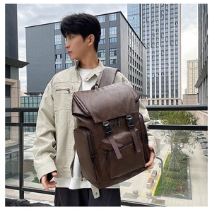 Outdoor shot of a brown PU leather backpack with double buckle straps and side pockets