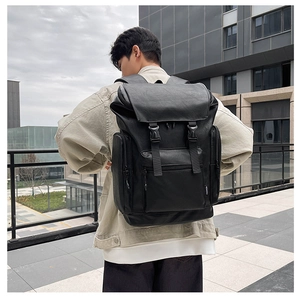Detail of waterproof black PU leather backpack with buckle straps and fashion label tag