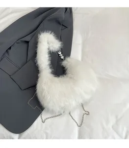Close-up of white faux fur texture with heart-shaped silver links and pearl chain details