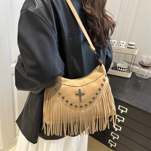 Sac à bandoulière en daim kaki avec franges et rivets métalliques porté par un mannequin