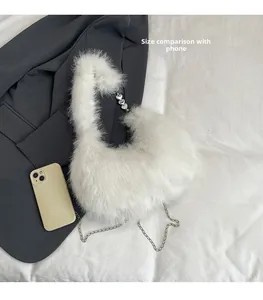 White faux fur handbag detail with metal chain and heart pendant next to a smartphone