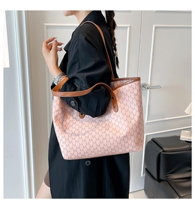 Detail view of pink tote bag with M-letter jacquard and contrast brown leather trim