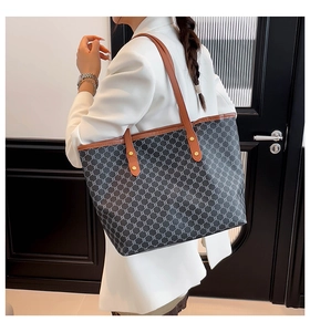 Macro detail of the vintage geometric pattern and brown leather trim on a large tote bag