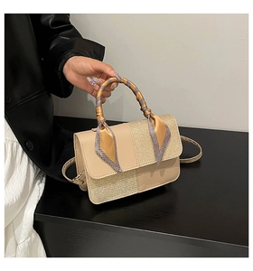 Close-up of beige leather and gold sequin handbag with houndstooth silk scarf on handle