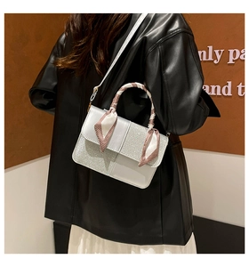 Detail of silver leather handbag featuring diamond glitter panels and scarf wrapped handle