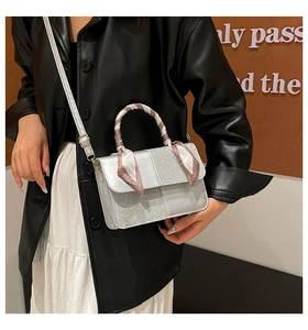 Chic silver crossbody bag with sequin patchwork and red silk scarf detail on handle