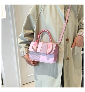 Detail of light pink crossbody bag with glitter panels and silk scarf wrapped handle