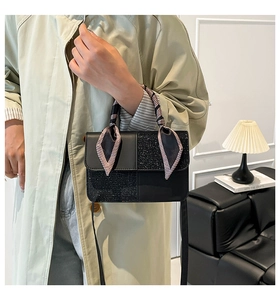 Detail of black crossbody bag featuring textured glitter panels and silk houndstooth scarf wrap