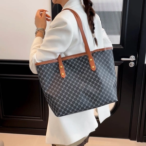 Large black canvas tote bag with geometric patterns and brown leather straps for commuting