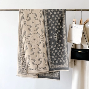 Detail view of paisley pattern shawl draped with fashion props in minimalist setting