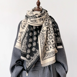 Detail of paisley and geometric pattern scarf with fringe, shown on a wooden mannequin