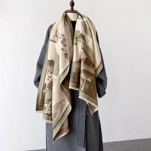 Detail of elegant lotus pattern shawl with tassels styled on a grey wool coat