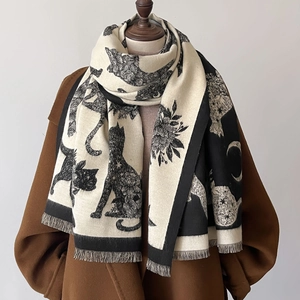 Close-up of cat and floral jacquard pattern on knitted shawl with fringe details
