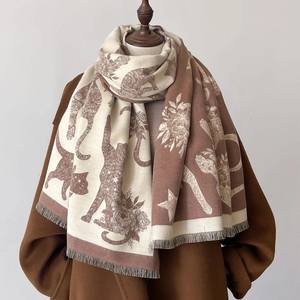 Cat pattern knitted shawl in caramel and beige with tassels on a mannequin