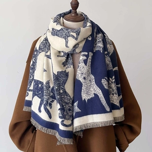 Detailed close-up of navy blue and beige jacquard knit shawl with cat and star patterns