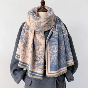 Detail of floral cashmere-like scarf with fringe on grey coat, beige and blue jacquard design