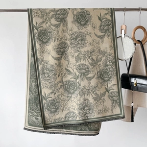 Detailed view of peony floral jacquard pattern and fringe edge on dark green shawl