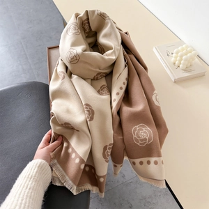Detail of camellia and polka dot knit scarf with soft fringe edges and warm texture