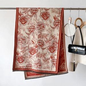 Close-up of elegant cream cashmere shawl with red peony pattern and grey tassels
