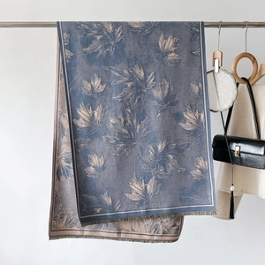 Detailansicht des Ahornblatt-Jacquardmusters auf elegantem blaugrauem Schal mit Fransen