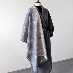 Detail eines blau-beigen Pashminas mit Ahornblattmuster und Fransen am Wollmantel