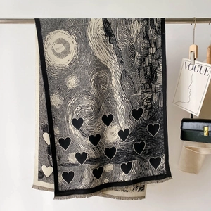Dettaglio ravvicinato della sciarpa jacquard con motivi a cuore, frange e texture stellate