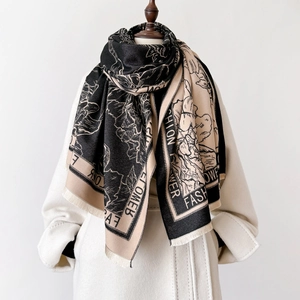 Ethnic floral pattern cashmere-feel scarf worn on a white wool coat in a main studio shot
