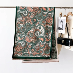 Détail d'un châle cachemire avec motifs mandala corail et vert foncé et franges