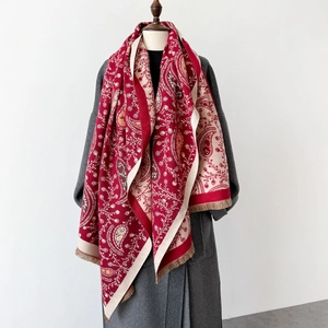Detail of red and beige paisley shawl with tassels on a wool coat mannequin