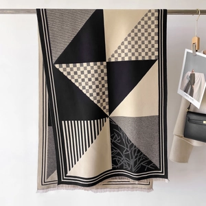 Detail of a minimalist geometric plaid scarf with premium knit texture and fringe trim