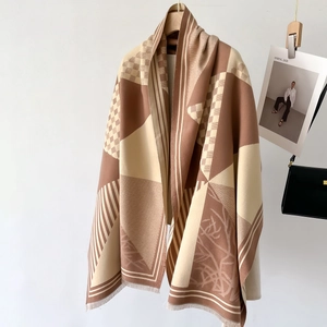 Checkboard patchwork knit scarf in earth tones with tassels on a white background