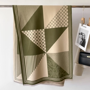 Detail of olive and beige geometric pattern scarf with fine fringe tassels and elegant texture