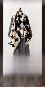 Detail of winter scarf featuring black and white geometric patterns and tassel edges