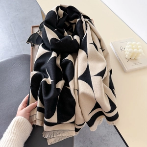 Minimalist geometric knit scarf with fringe and large abstract circular pattern in beige and black